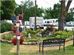 View larger image of A park bench next to a flower garden at RIVERSIDE RV PARK image #4