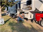 Couple sitting in chairs next to their RV at CEDAR VALLEY RV PARK - thumbnail