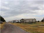 Row of Fifth-wheelers in grassy area at CEDAR VALLEY RV PARK - thumbnail
