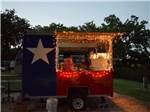 View larger image of Lit concession stand decorated like Texas flag at PECAN PARK RIVERSIDE RV PARK image #9