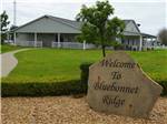 View larger image of The front entrance sign and building at BLUEBONNET RIDGE RV PARK  COTTAGES image #1