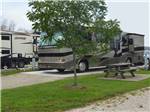 View larger image of A motorhome on a paved RV site at BLUEBONNET RIDGE RV PARK  COTTAGES image #12