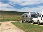 A travel trailer and truck in an RV site at PETER D'S RV PARK - thumbnail