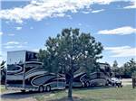 A large motorhome pulling a trailer in a pull thru site at NORTH PARK RV CAMPGROUND - thumbnail