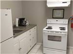 Small kitchen area with stove, coffee maker and fridge at NORTH PARK RV CAMPGROUND - thumbnail