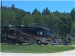 RVs and motorcycles at grass and gravel sites at Custer's Gulch RV Park & Campground - thumbnail