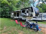 A motorcycle and trailer in an RV site at WHITE ACRES CAMPGROUND - thumbnail
