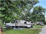 A travel trailer in a gravel RV site at WHITE ACRES CAMPGROUND - thumbnail