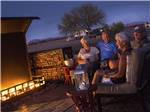 People sitting around a fireplace drinking wine at SONORAN DESERT RV PARK - thumbnail