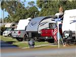 A row of RVs in back in spaces at TICE COURTS & RV PARK - thumbnail