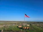 A bench to sit and view the valley and an American flag at 7TH RANCH RV PARK - thumbnail