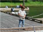 A small boy fishing off the dock at LOON LAKE LODGE & RV RESORT - thumbnail