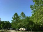 Travel trailers parked at sites among trees at Pony Express RV Park & Campground - thumbnail