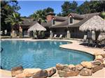 View larger image of Swimming pool with tiki umbrellas and tables at RAYFORD CROSSING RV RESORT image #5