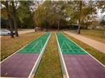 View larger image of Two shuffleboards with fall leaves around them at RAYFORD CROSSING RV RESORT image #9