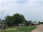Play structures in foreground, RV sites in back at TEXAN RV RANCH - thumbnail