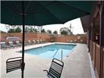 Swimming pool with lounge chairs at WILD FRONTIER RV RESORT - thumbnail