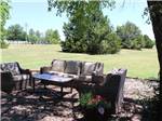 An outdoor seating area under trees at ARBUCKLE RV RESORT - thumbnail