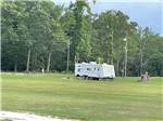 A travel trailer in a grassy field at ROCKY HOCK CAMPGROUND - thumbnail