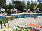 View larger image of The swimming pool with orange and blue lounge chairs at CAMPING LA CLE DES CHAMPS RV RESORT image #4