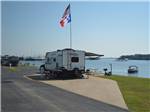 View larger image of Fifth wheel trailer parked in site next to the lake at THE VINEYARDS CAMPGROUND  CABINS image #1
