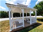 A white gazebo with a swinging bench at CAVE COUNTRY RV CAMPGROUND - thumbnail