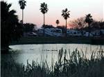 View larger image of RV sites by the water at dusk at LAZY PALMS RANCH RV PARK image #4