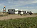 Row of motorhomes with sign in background at GOVERNORS' RV PARK CAMPGROUND - thumbnail