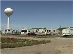 RVs with tall white water tower in the background at GOVERNORS' RV PARK CAMPGROUND - thumbnail