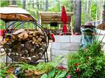 Patio area with a round log holder and frog statue at SANDY BEACH CAMPGROUND - thumbnail