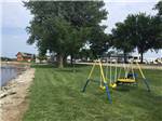 View larger image of A closer look of the playground with picnic benches in the distance at BAILEYS RV RESORT image #3