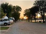 View larger image of Sun setting at the end of a gravel road at BAILEYS RV RESORT image #8