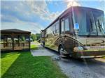 Class A parked at a site with a covered sitting area at The RV Resort at Carolina Crossroads - thumbnail