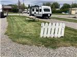 A white picket fence next to an RV site at OLD WEST RV PARK - thumbnail