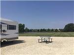 View larger image of An RV hooked up next to a picnic bench at MCPHERSON RV RANCH image #2