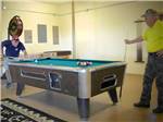 Men playing pool at OASIS RV RESORT - thumbnail