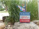 A sign on a rock that says Faith, Family and Freedom at LAKESHORE RV RESORT & CAMPGROUND - thumbnail
