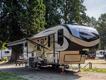 A fifth wheel RV near tall trees at Sun Retreats Birch Bay - thumbnail