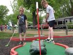 Kids playing mini golf - thumbnail