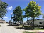 A line of gravel RV sites with a Taco Bell in the background at QUAIL RIDGE RV PARK - thumbnail