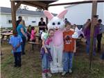 Kids taking a photo with the Easter bunny at FOUR OAKS LODGING & RV RESORT - thumbnail