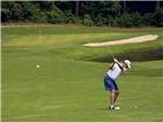 A man getting ready to hit a golf ball at FOUR OAKS LODGING & RV RESORT - thumbnail