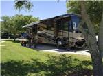 View larger image of A brown motorhome parked in one of the paved RV sites at GERONIMO RV PARK image #7