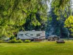 RV parked in site surrounded by trees - thumbnail