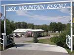 The front driveway with a sign over the road at SKY MOUNTAIN RESORT RV PARK - thumbnail