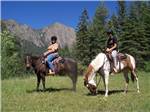 A couple of people riding horses at SKY MOUNTAIN RESORT RV PARK - thumbnail