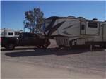 A fifth wheel trailer and truck in an RV site at 3 DREAMERS RV PARK - thumbnail