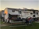 Couple watching TV outside their RV at COYOTE VIEW RV PARK & RV REPAIR - thumbnail