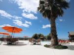 Pool area with tables, chairs and umbrellas at YOSEMITE RV RESORT - thumbnail