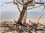 View larger image of A person laying in a hammock near the ocean at LEVY COUNTY VISITORS BUREAU image #2